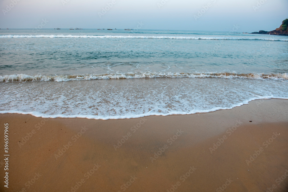 Goa/ India 09 November 2020 Sandy beach and soft White ocean Waves early in the morning at Baga Beach Goa ....