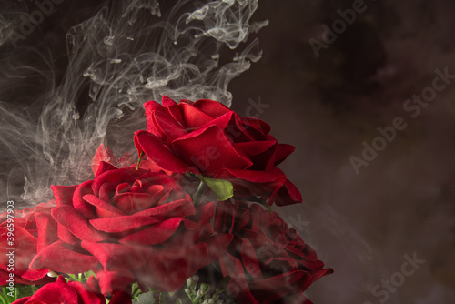 Cascade of smoke beautifully covering a bouquet of fabric flowers, abstract background, selective focus.