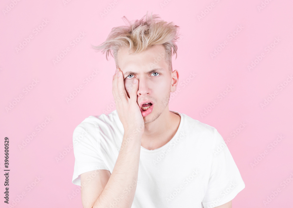 Young handsome man in a white T-shirt is tired and wants to sleep. Supports his face with his hand to stay awake. Sleep, fatigue and stress concept. Young handsome man in a white T-shirt is tired and wants to sleep. Supports his face with his hand to stay awake. Sleep, fatigue and stress concept.