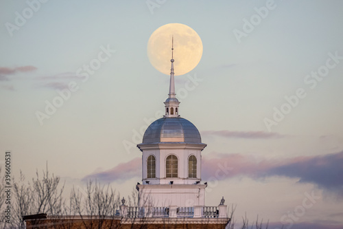 Full moon rising behind a beautiful building with a white steeple. Garden City, New York photo