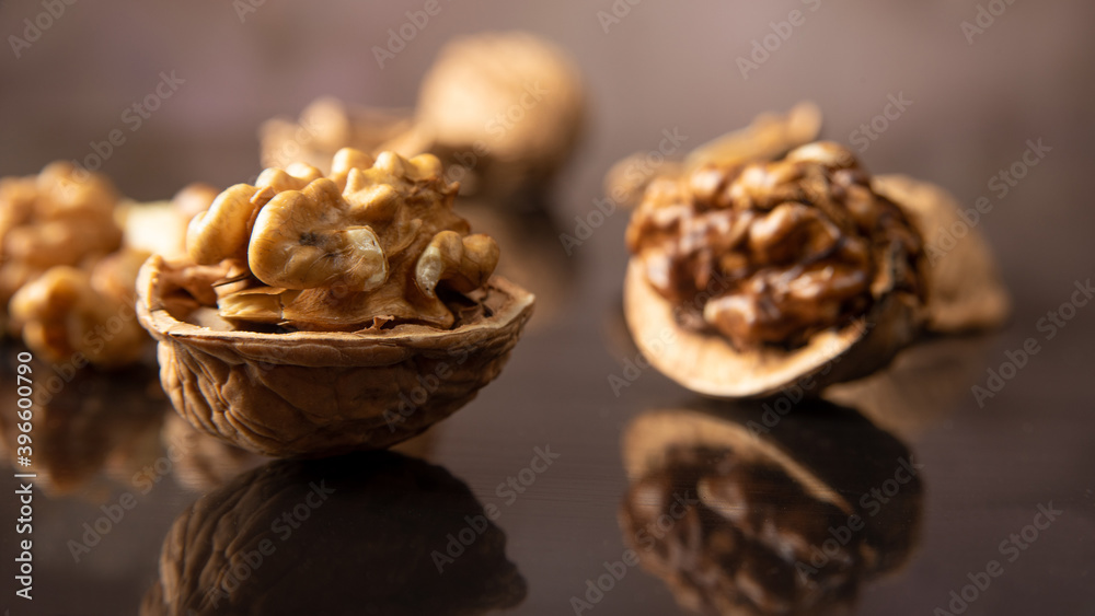 Nuts, details of nuts scattered on a black reflective surface, abstract background, selective focus. Nuts, details of nuts scattered on a black reflective surface, abstract background, selective focus.