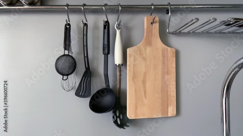 Slow motion footage with kitchenware swinging on a special kitchen bar with natural lighting 