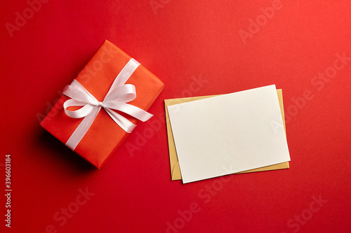 Greeting card mockup with gift box on red background