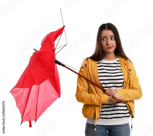 Emotional woman with umbrella broken by gust of wind on white background