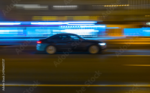 car drives along a city street at night.