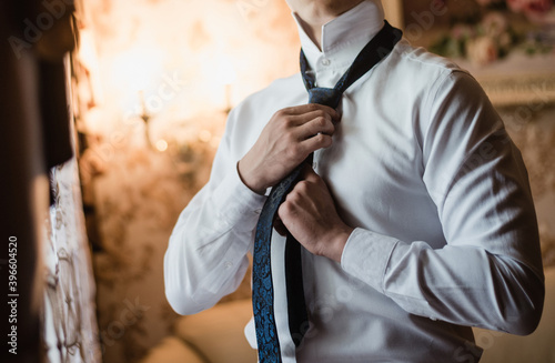 Photos the groom straightens his tie, man in a tie, The morning of the groom, bridegroo