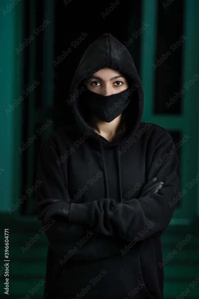 Thief broke into the apartment. House robbery by woman in a black jacket and black mask and crowbar. Burglar in a mask. Thief in a mask trying to break into other people's house Thief broke into the apartment. House robbery by woman in a black jacket and black mask and crowbar. Burglar in a mask. Thief in a mask trying to break into other people's house