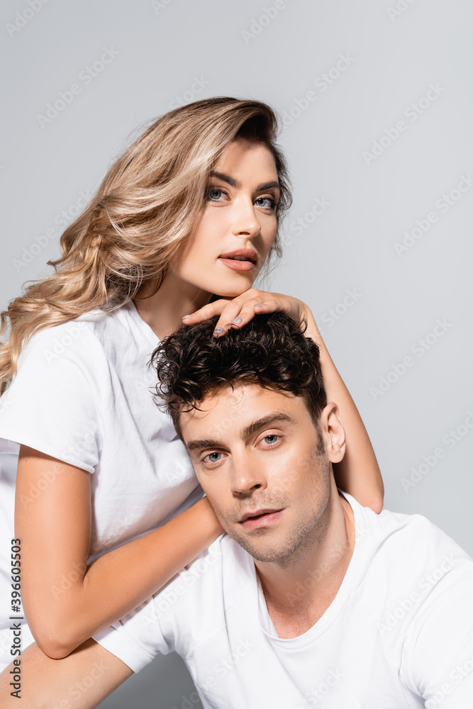Fototapeta premium couple in white t-shirts embracing isolated on grey