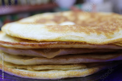 plate with overlaid pancakes and butter on top, homemade food