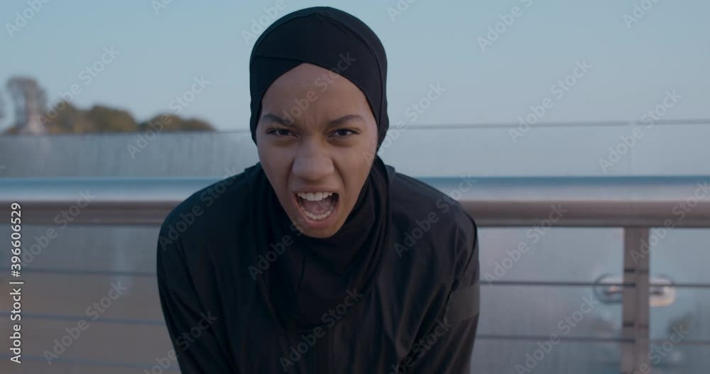 Young muslim woman in hijab trying to catch her breath after running ...