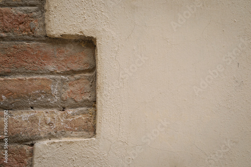 old brick wall with beige painted cement wall, space for text and a background © YK