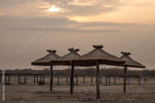 Reed and wood beach umbrellas on the beach - Sulina, Romania