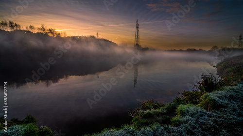 Autumn landscape with fog and frost with a river at sunrise