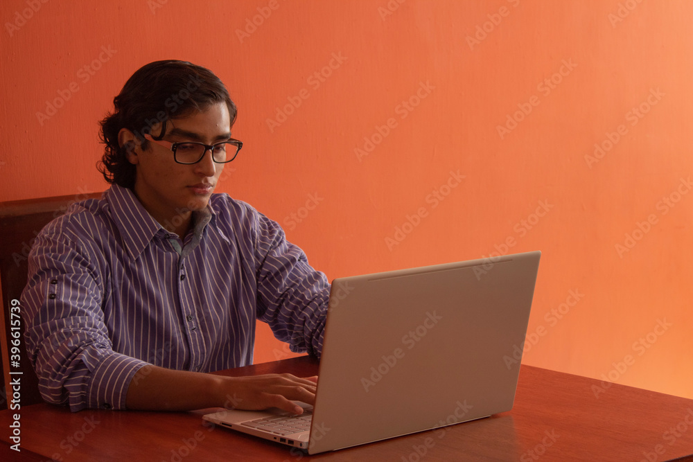 Young latin man working on his computer Young latin man working on his computer