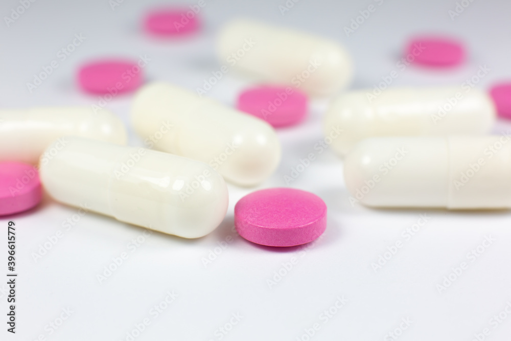Colored pills on white background. Close up. Medical treatment concept. Colored pills on white background. Close up. Medical treatment concept.