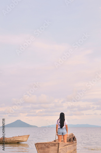 Rear view of woman looking at sky while standing on boat in the middle of lake Managua