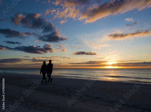 Silhouette of a couple walking on the beach at sunset on the Gulf of Mexico at St. Pete Beach, Florida. © geraldmarella