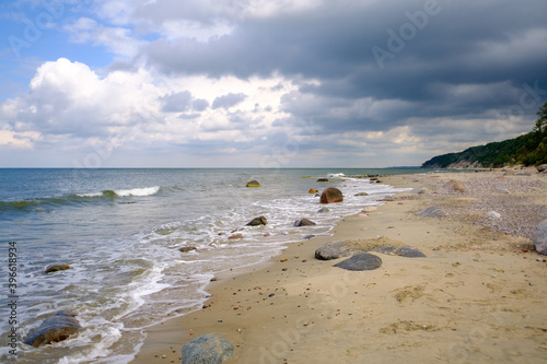 Fototapeta Naklejka Na Ścianę i Meble -  Waving sea and sandy shore on cloudy day