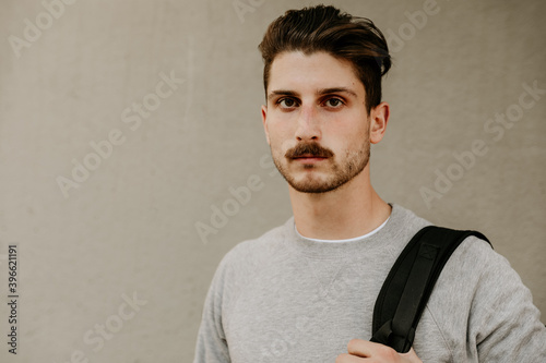 Handsome bearded hipster man walking outdoor. City life style.