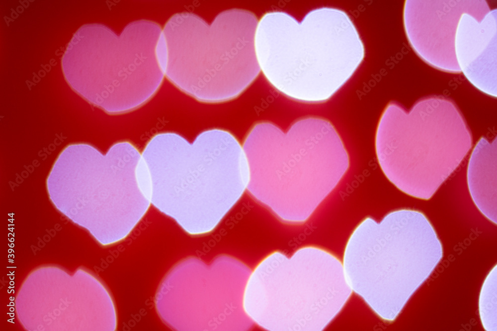 Background of different colors defocused lights with a heart shape on a red background. Abstract image. Valentine, love and passion concept