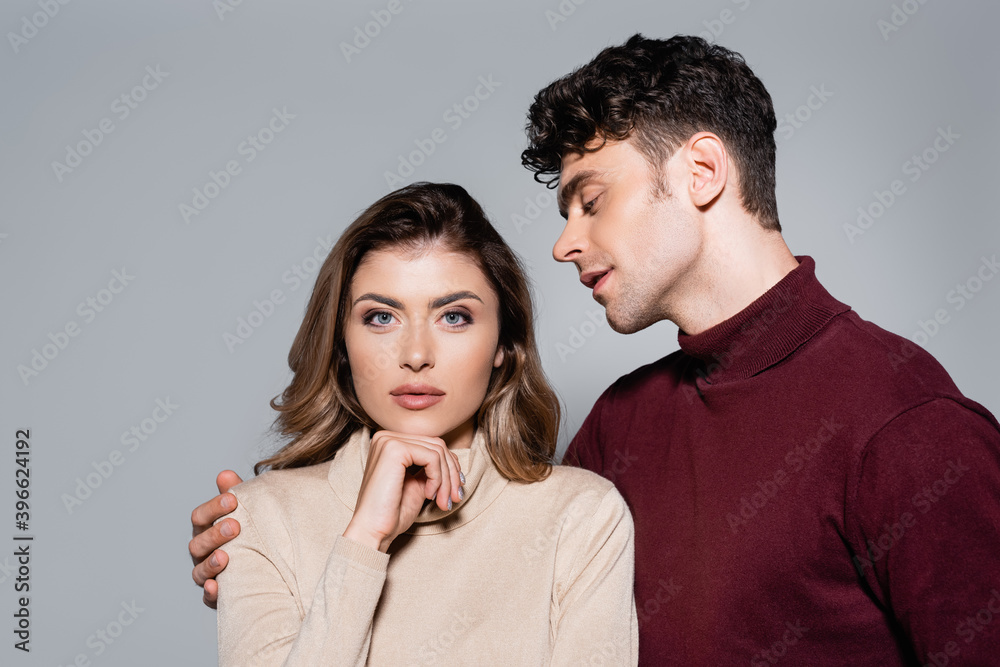 young couple in jumpers posing isolated on grey young couple in jumpers posing isolated on grey