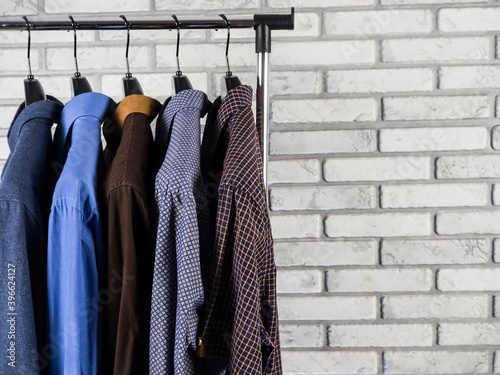 Shirts of different colors are hanging on a hanger. Men's wardrobe. Style and fashion. Background and texture.