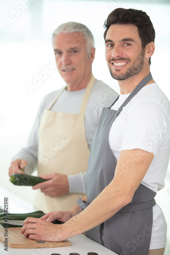 hipster son with his senior father cooking