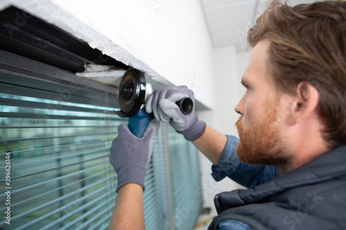 Konstfotografi young man as a home improvement while grinding window frame