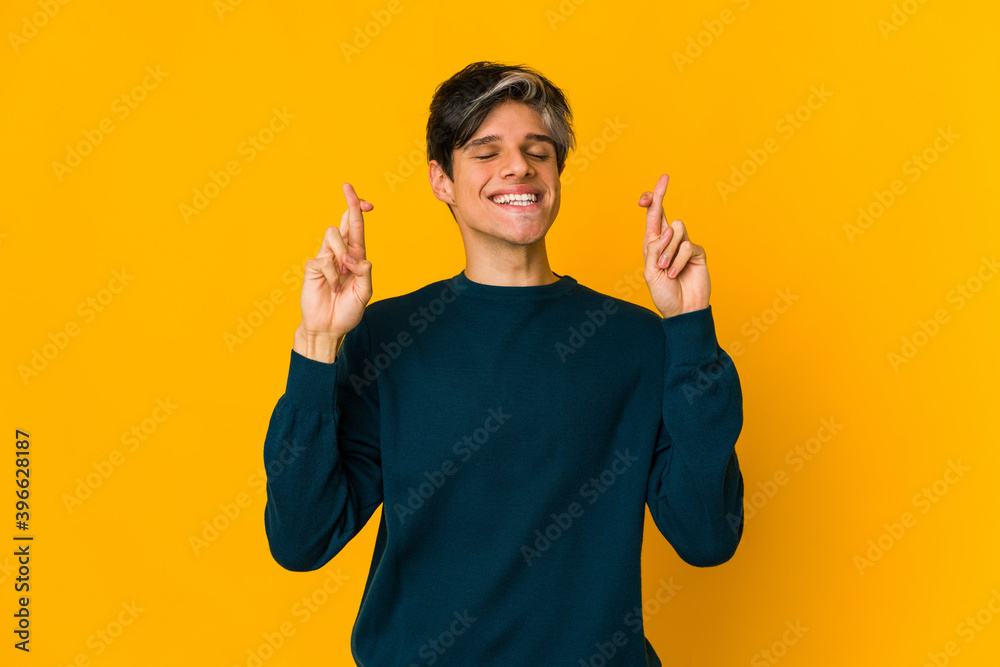 Young skinny hispanic man crossing fingers for having luck Young skinny hispanic man crossing fingers for having luck