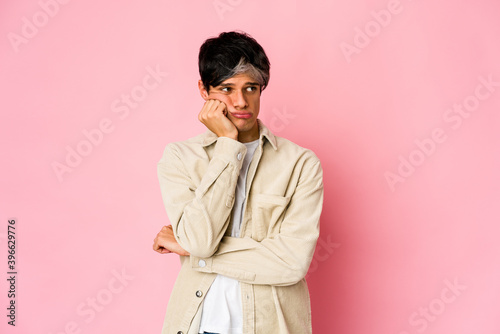 Young skinny hispanic man who feels sad and pensive, looking at copy space.