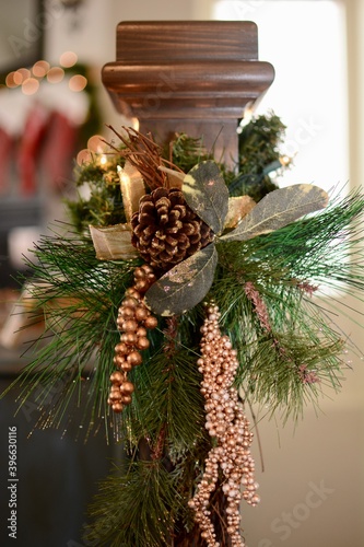 Christmas decorations with pine cones, gold ribbon, green fir and gold balls on a banister isolated.