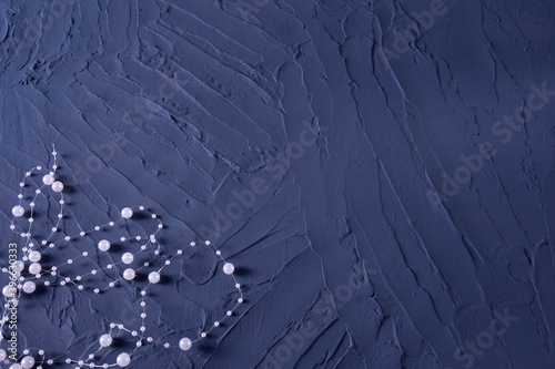 body jewelry in the form of beads on a dark blue rough background photo