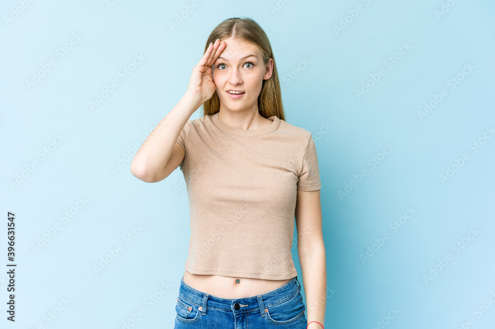 Young blonde woman isolated on blue background shouts loud, keeps eyes opened and hands tense. Young blonde woman isolated on blue background shouts loud, keeps eyes opened and hands tense.