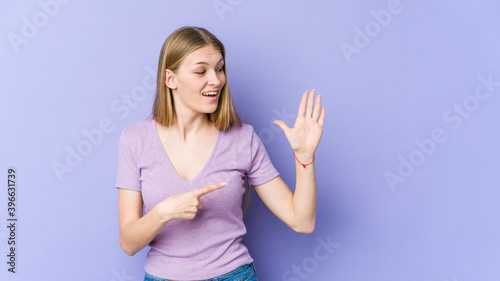 Young blonde woman isolated on purple background smiling cheerful showing number five with fingers.