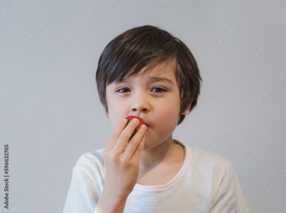 Portrait Healthy kid eating strawberries, Selective focus Hungry little boy looking at strawberry on his hand with smiling face, Child tasting fresh strawberry, Healthy summer food for Children Portrait Healthy kid eating strawberries, Selective focus Hungry little boy looking at strawberry on his hand with smiling face, Child tasting fresh strawberry, Healthy summer food for Children