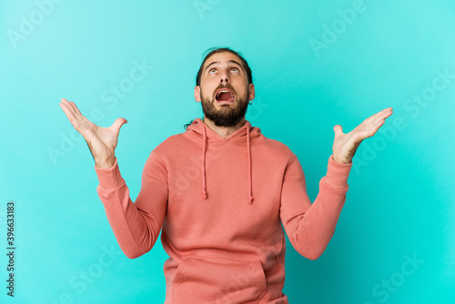 Young man with long hair look screaming to the sky, looking up, frustrated. photo