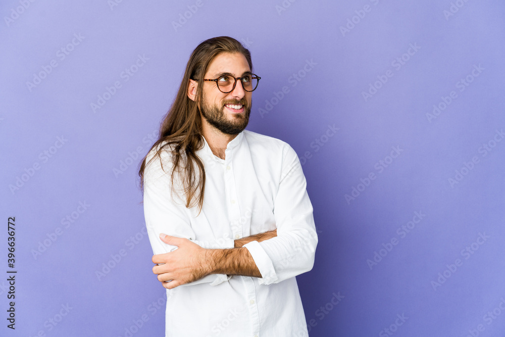 Young man with long hair look smiling confident with crossed arms.