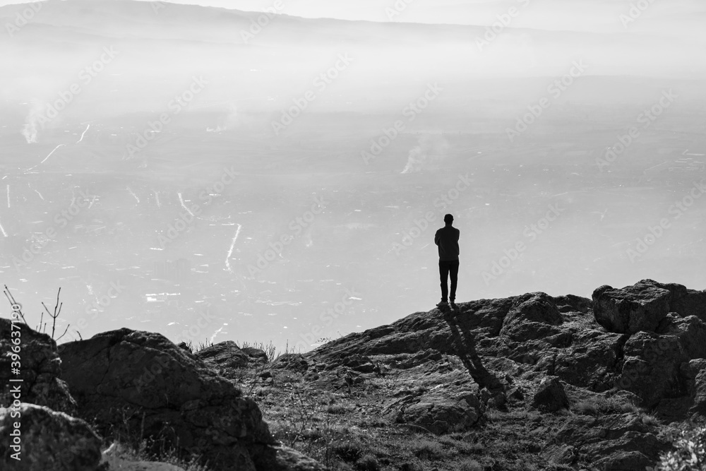 Young man standing on top of the mountain