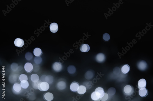 Abstract pattern of white bokeh lights on a dark background