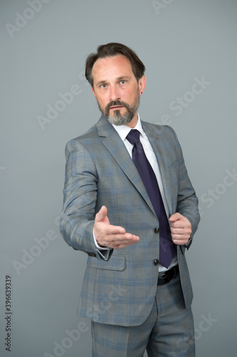 handsome adult boss man in office wear with tie going to shake hand, business relations