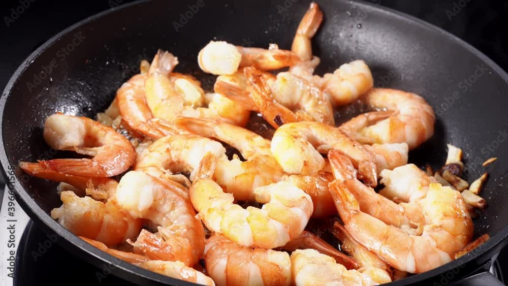 Cooking prawns in a frying pan on stove Cooking prawns in a frying pan on stove