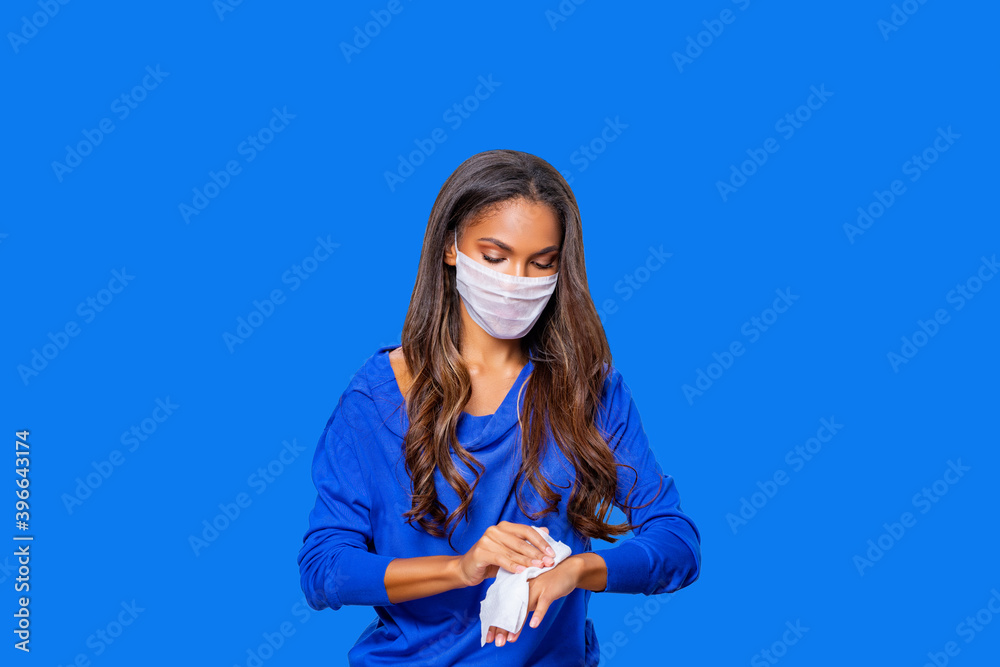 Black woman disinfects his Hands with an Antiseptic napkin. Wet wipes for hand disinfection. Hygiene procedures. Prevention of viral and bacterial diseases. Care. blue background. isolated. Black woman disinfects his Hands with an Antiseptic napkin. Wet wipes for hand disinfection. Hygiene procedures. Prevention of viral and bacterial diseases. Care. blue background. isolated.