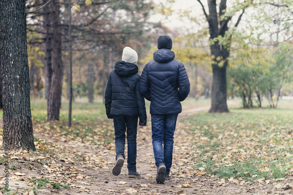 teen girl and boy walking through the park and enjoys autumn, beautiful nature with yellow leaves teen girl and boy walking through the park and enjoys autumn, beautiful nature with yellow leaves