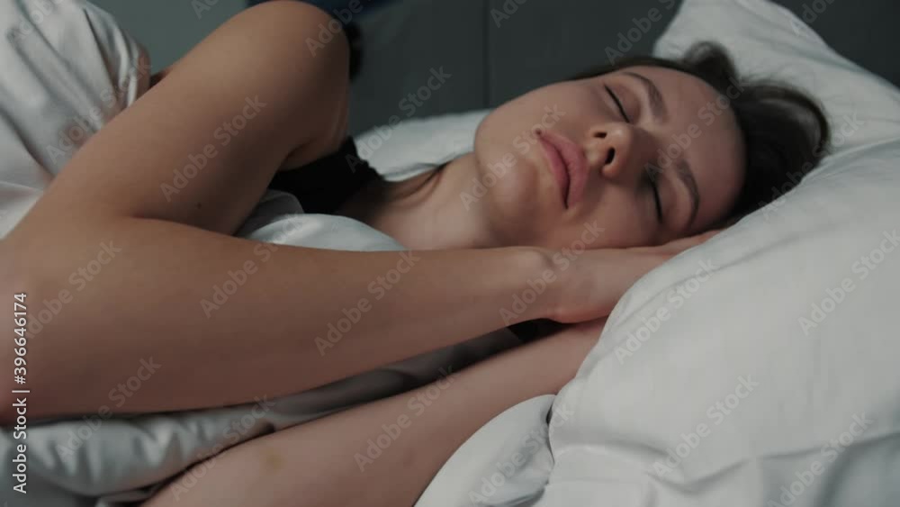 Close up portrait of relaxed woman sleeping on a white pillow in bed. Portrait of young Caucasian woman resting in bedroom at home. Leisure and relaxation. Close up portrait of relaxed woman sleeping on a white pillow in bed. Portrait of young Caucasian woman resting in bedroom at home. Leisure and relaxation.