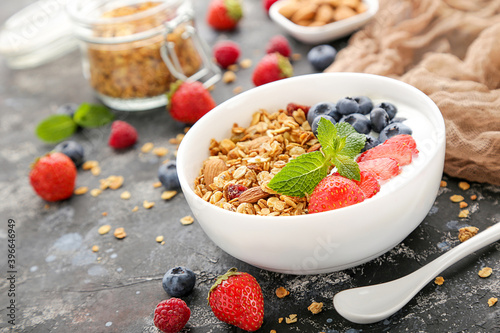 Tasty granola with fresh berries on grey background