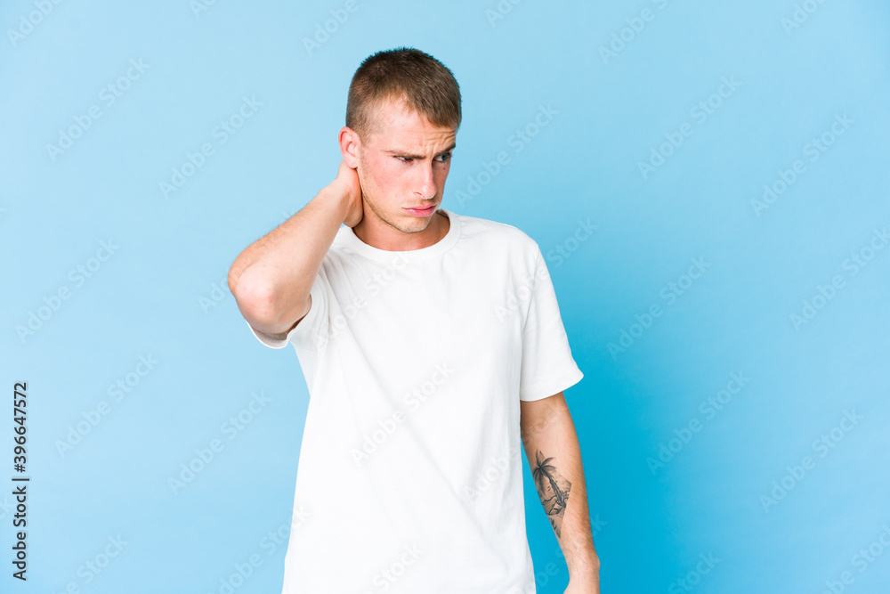 Young caucasian handsome man having a neck pain due to stress, massaging and touching it with hand. Young caucasian handsome man having a neck pain due to stress, massaging and touching it with hand.