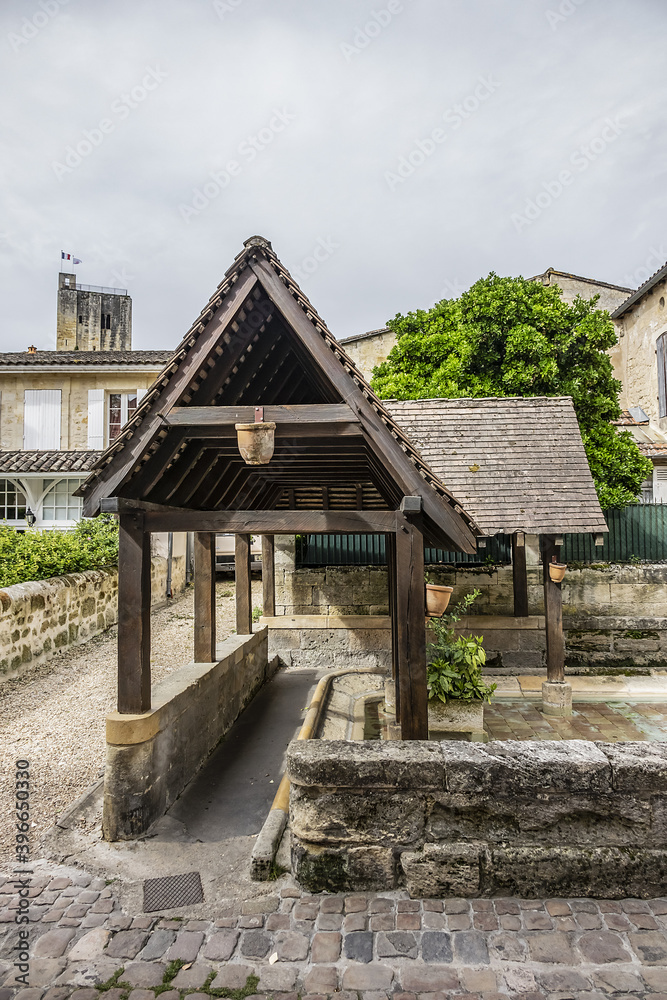 View of old Washhouse with King's Fountain (Fontaine du Roi). Washhouse - public pond (19th century), where washerwomen washed linen or rather rinsed it. Saint Emilion, Gironde, France.