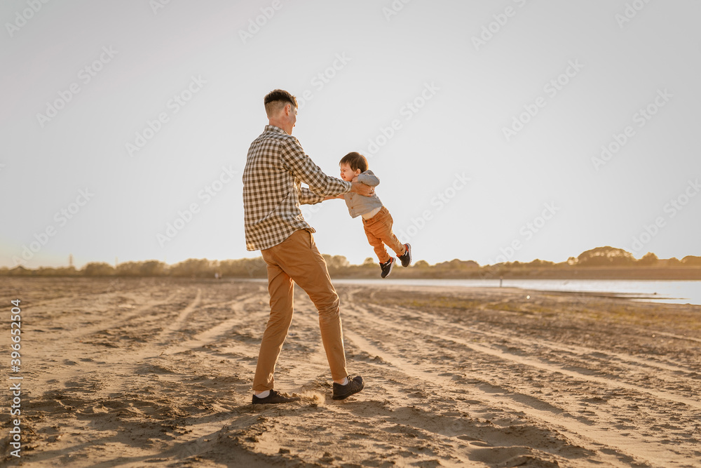 Portrait of loving father and his one years old son walking and playing outdoors Portrait of loving father and his one years old son walking and playing outdoors