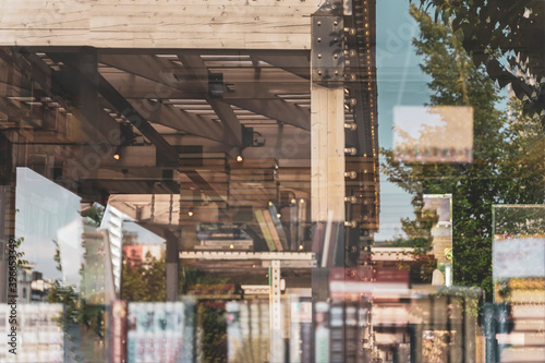 Obraz na płótnie Blurred bookshelfs of bookstore with colorful books, reflections of street views of city streets in the glass showcase