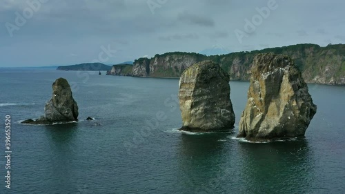 Aerial around view of Three brother rocks, Avacha bay, Kamchatka peninsula, Russia, 4k